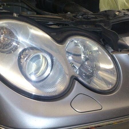 Scheinwerferaufbereitung an einem silbernen Auto