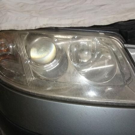 Scheinwerferaufbereitung an einem silbernen Auto
