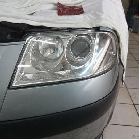 Scheinwerferaufbereitung an einem silbernen Auto