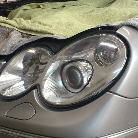 Scheinwerferaufbereitung an einem silbernen Auto
