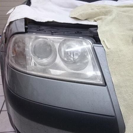 Scheinwerferaufbereitung an einem silbernen Auto