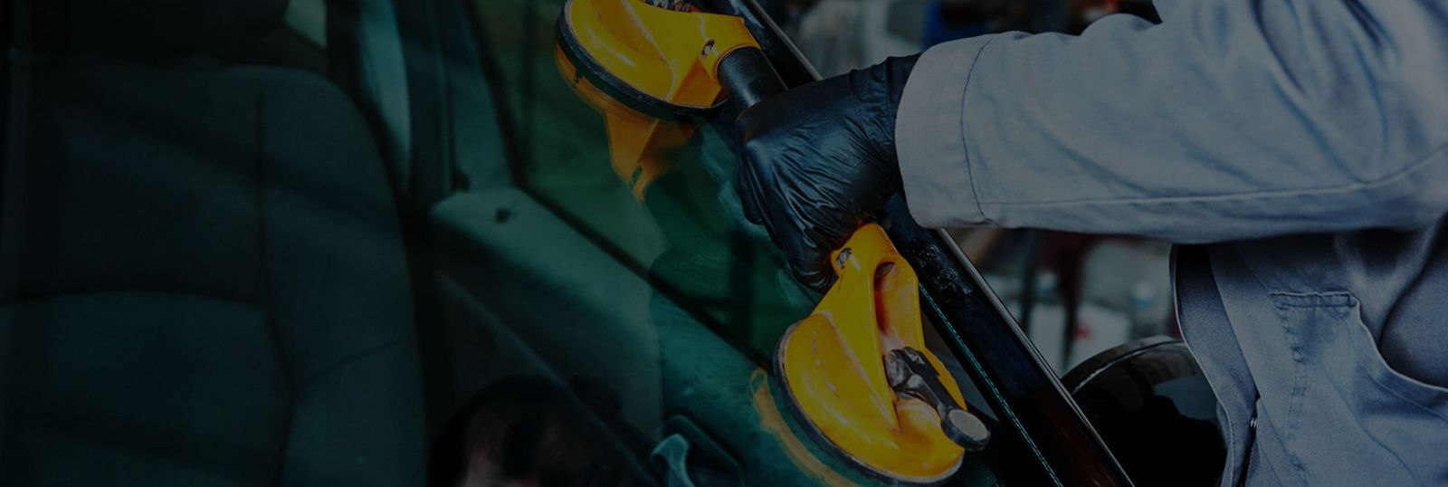 Ein Mitarbeiter mit Handschuhen setzt eine neue Frontscheibe ein