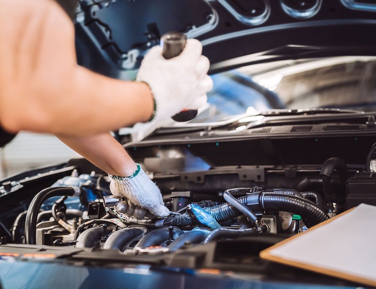Eine Person beurteilt den Zustand des Motors mit einer Taschenlampe in der Hand